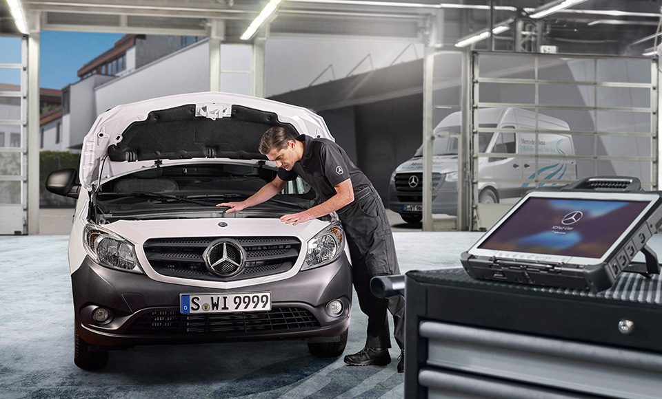 Werkstattmitarbeiter arbeitet am Motor eines weißen Citan